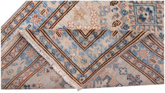A folded Afghan Super Kazakh runner featuring traditional blue and beige geometric patterns.
