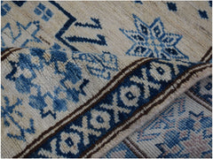 A folded Afghan Super Kazakh runner featuring traditional blue and cream geometric patterns.