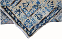 A handmade Afghan Super Kazakh runner featuring a geometric blue and beige pattern.
