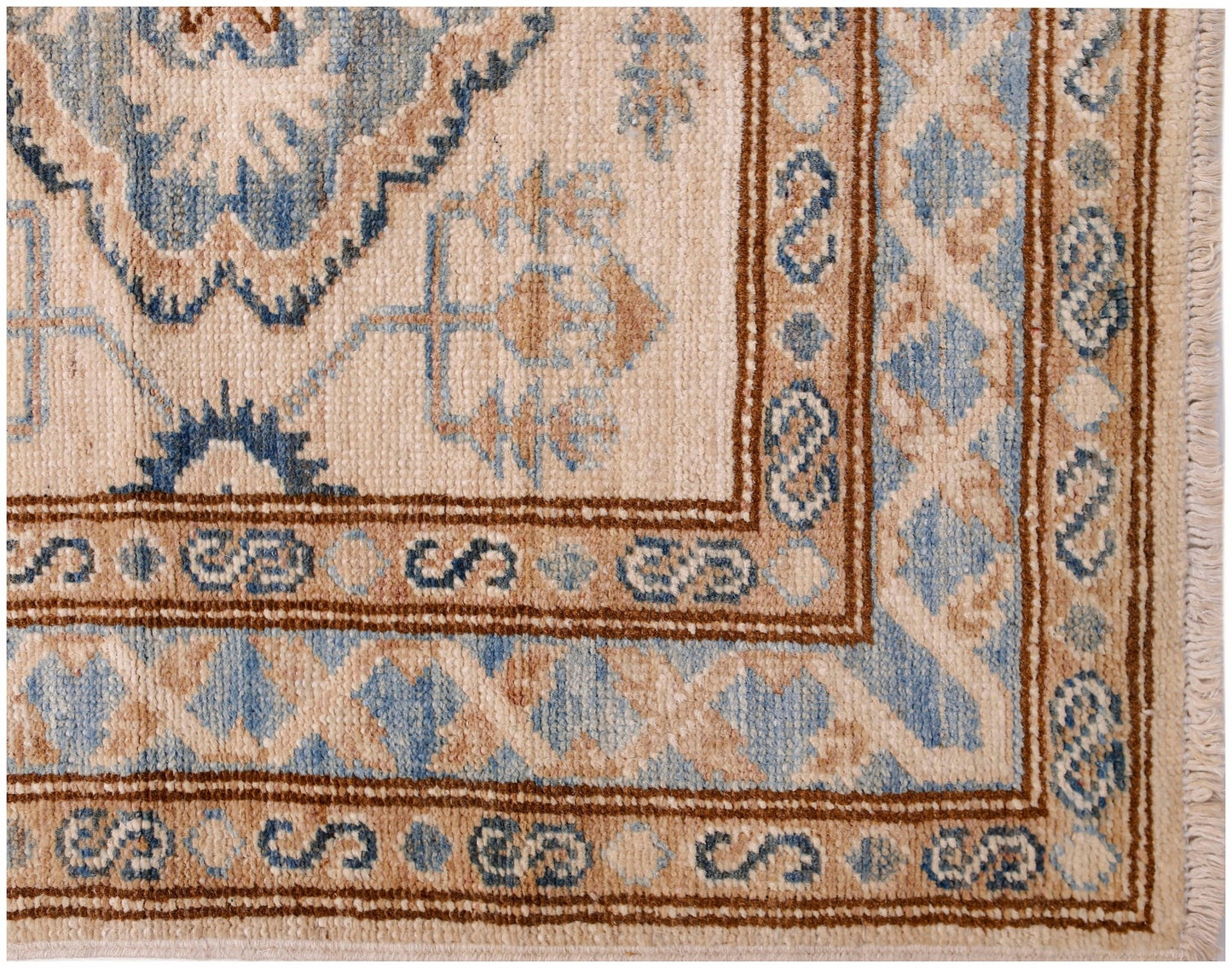A handmade Afghan Super Kazakh runner featuring traditional blue and tan geometric patterns.