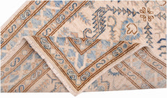 A folded Afghan Super Kazakh runner featuring traditional blue and tan geometric patterns.