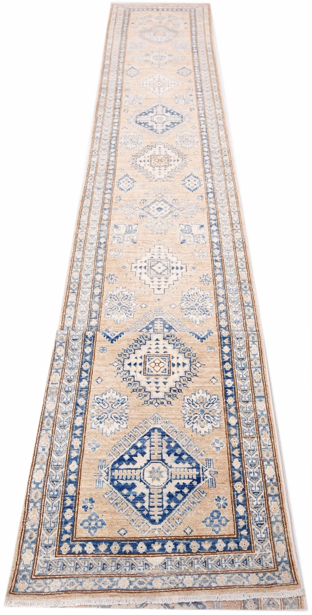 A long, handmade Afghan Super Kazakh runner featuring traditional blue geometric motifs on beige.