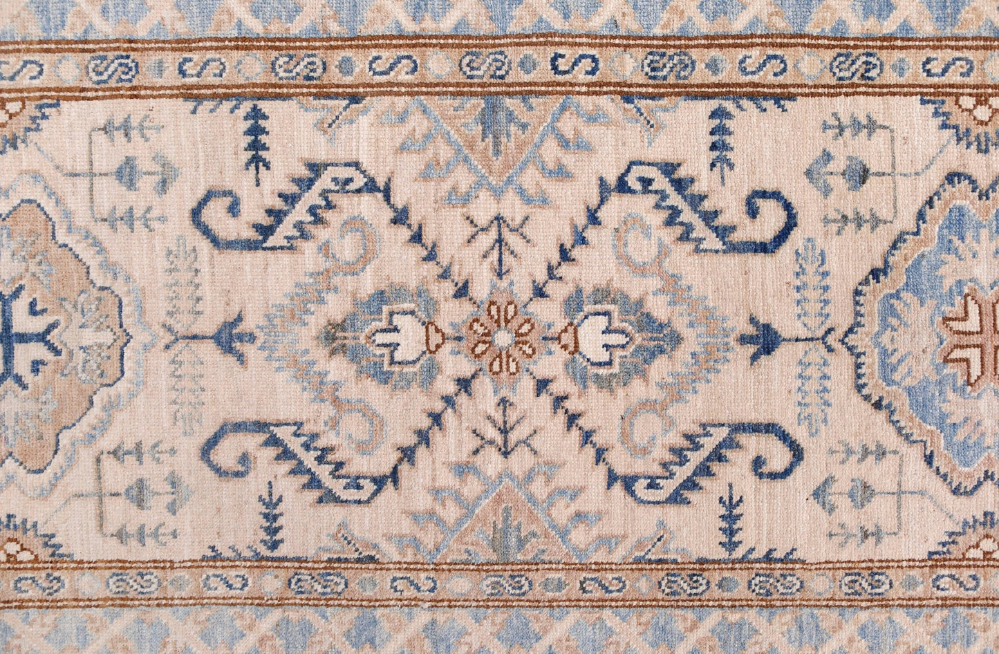 An Afghan Super Kazakh runner featuring traditional blue and tan geometric motifs on a cream field.