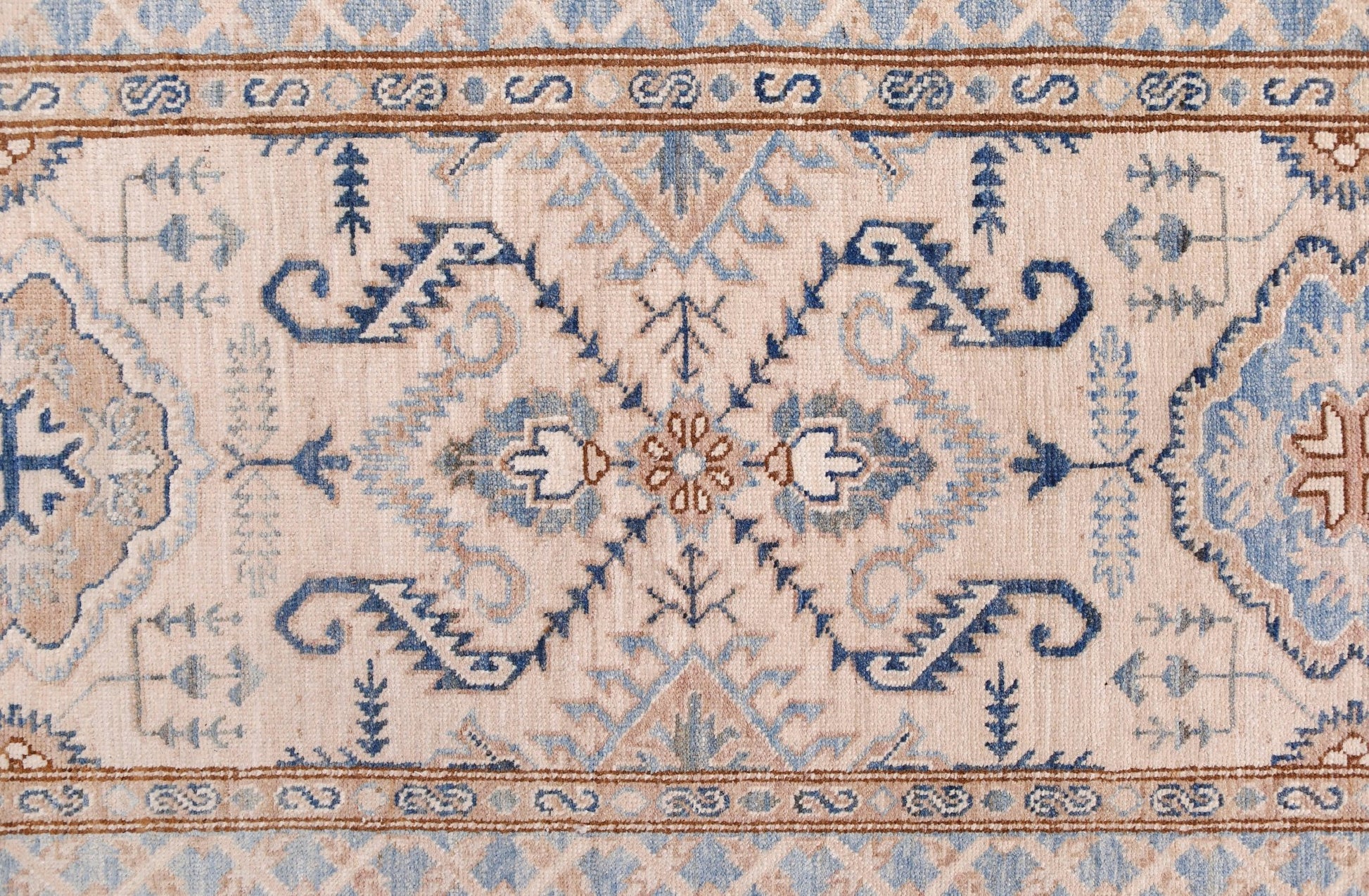 An Afghan Super Kazakh runner featuring traditional blue and tan geometric motifs on a cream field.
