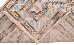 A folded Afghan Super Kazakh runner featuring traditional blue and brown geometric patterns.