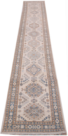 A long, handmade Afghan Super Kazakh runner rug featuring traditional geometric motifs in blue and tan.