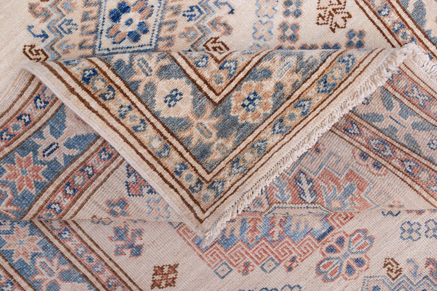 A handmade Afghan Super Kazakh runner featuring traditional geometric motifs in blue, pink, and cream.