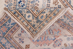 A handmade Afghan Super Kazakh runner featuring traditional geometric motifs in blue, pink, and cream.