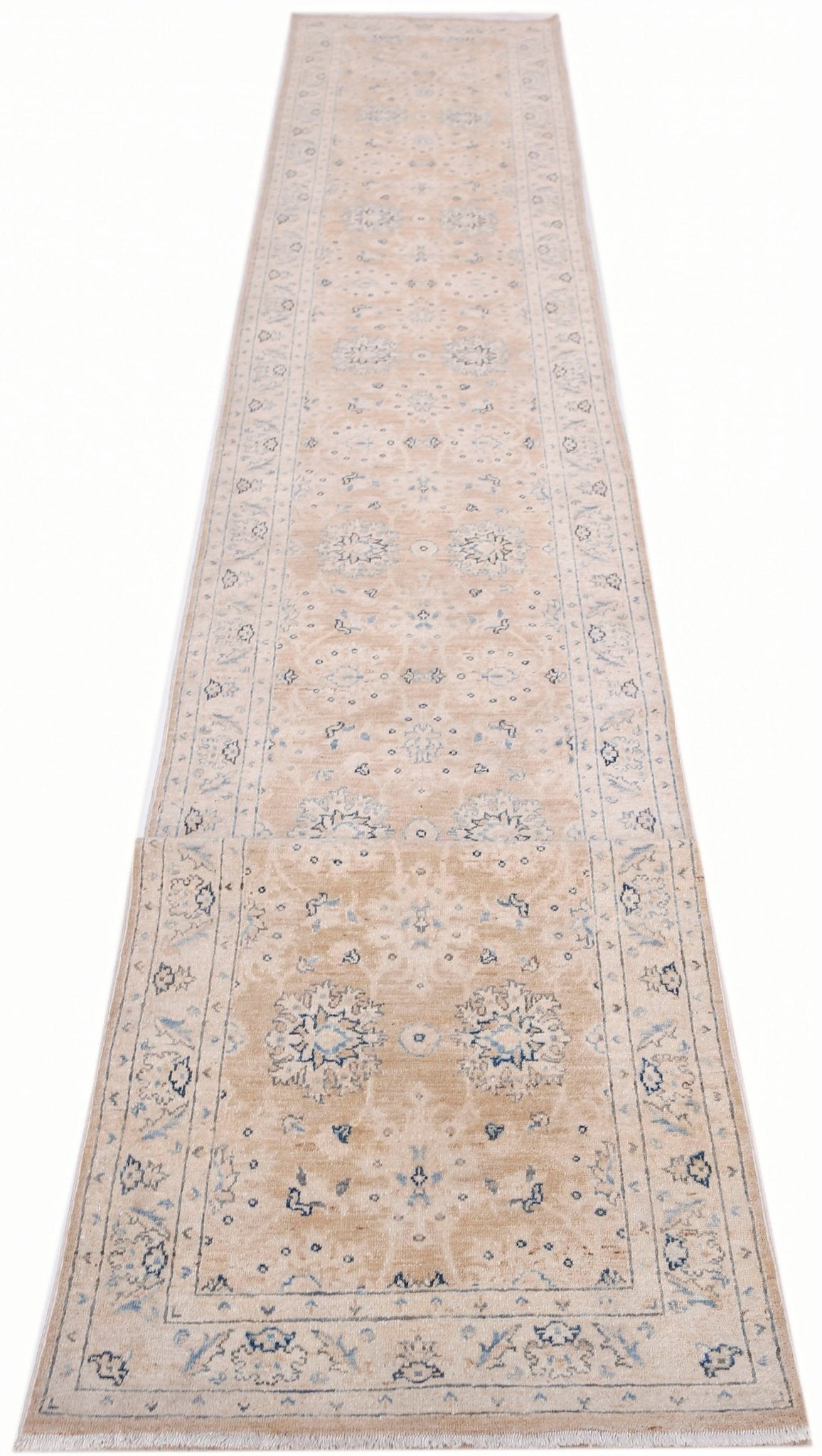 A long, handmade Afghan Super Kazakh runner rug featuring traditional blue motifs on a beige base.