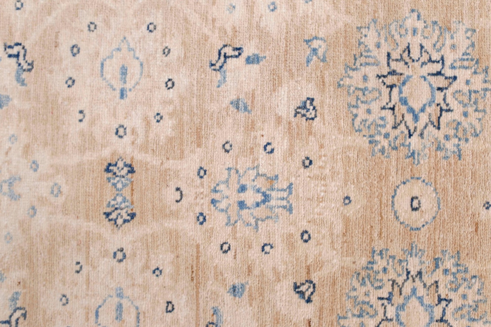A handmade Afghan Super Kazakh runner featuring traditional blue floral motifs on a beige wool base.