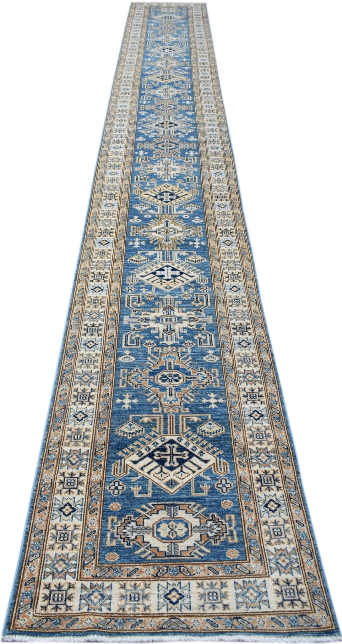 A long, handmade Afghan Super Kazakh runner rug featuring traditional geometric motifs in blue and tan.