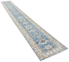 A long, handmade Afghan Super Kazakh runner rug featuring traditional blue and beige geometric motifs.