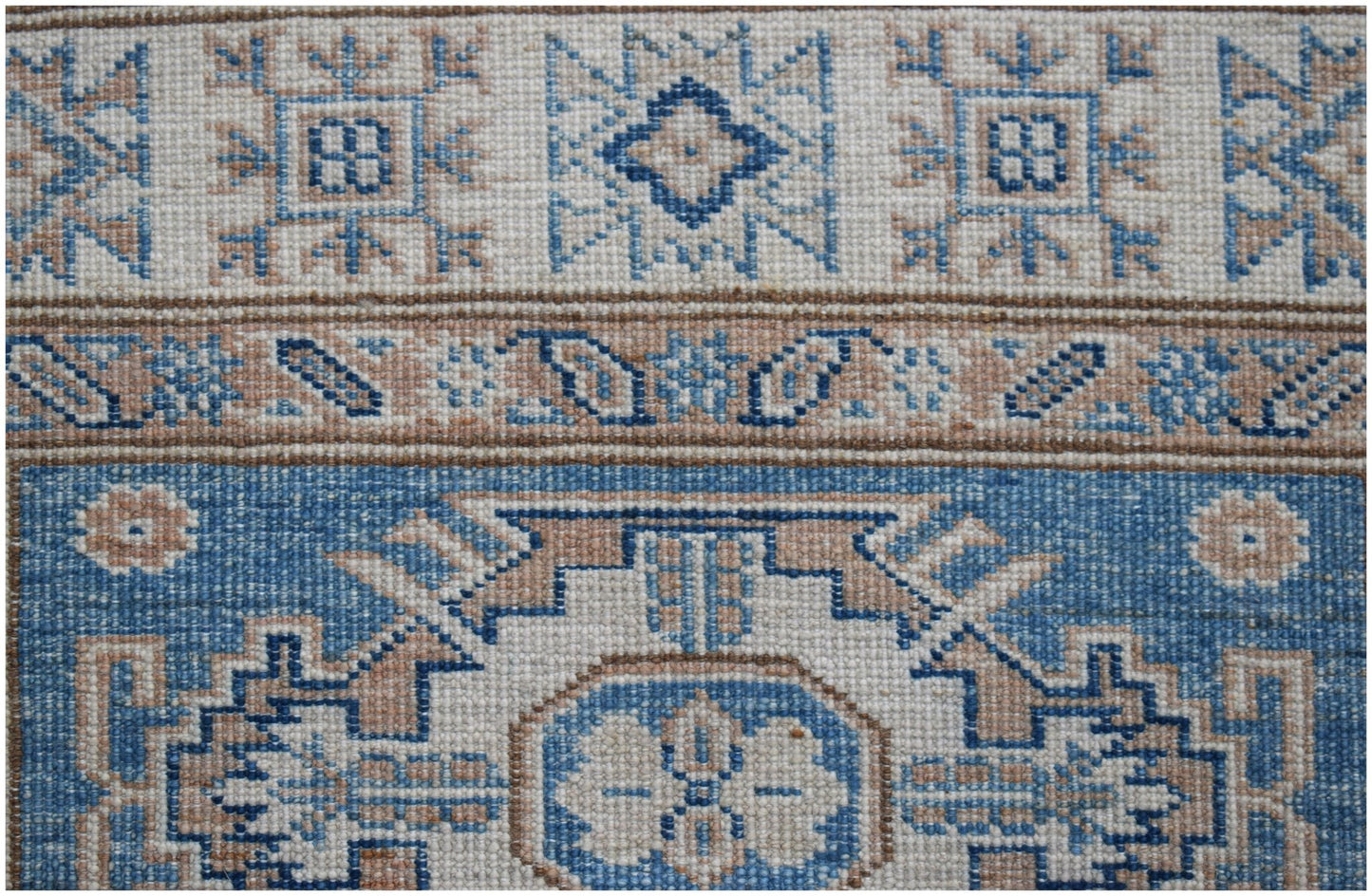 A handmade Afghan Super Kazakh runner featuring traditional geometric motifs in blue and beige.