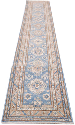 A long, handmade Afghan Super Kazakh runner rug featuring traditional geometric motifs in blue and tan.