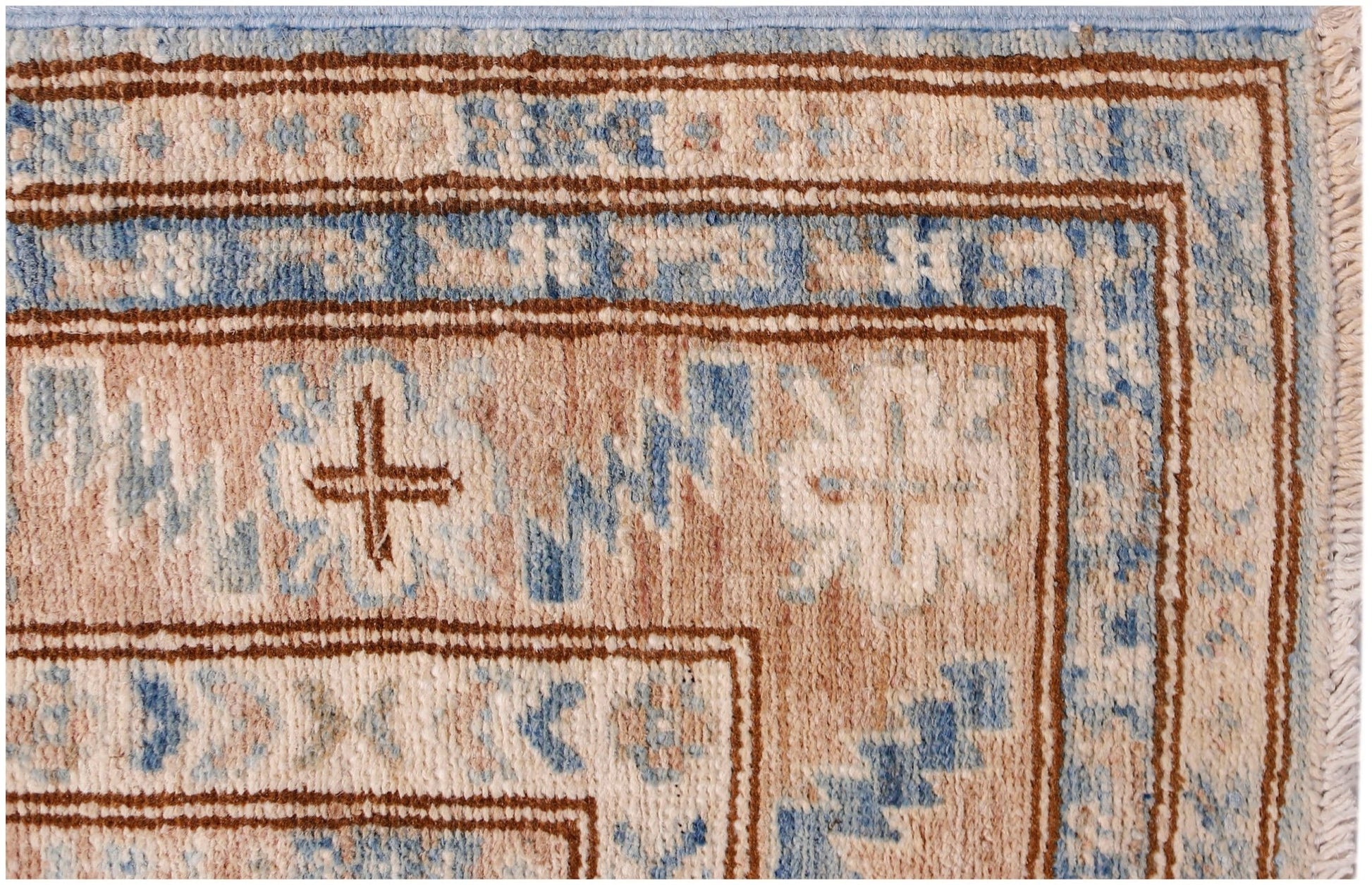 A close-up of an Afghan Super Kazakh runner featuring traditional geometric motifs in blue and tan.