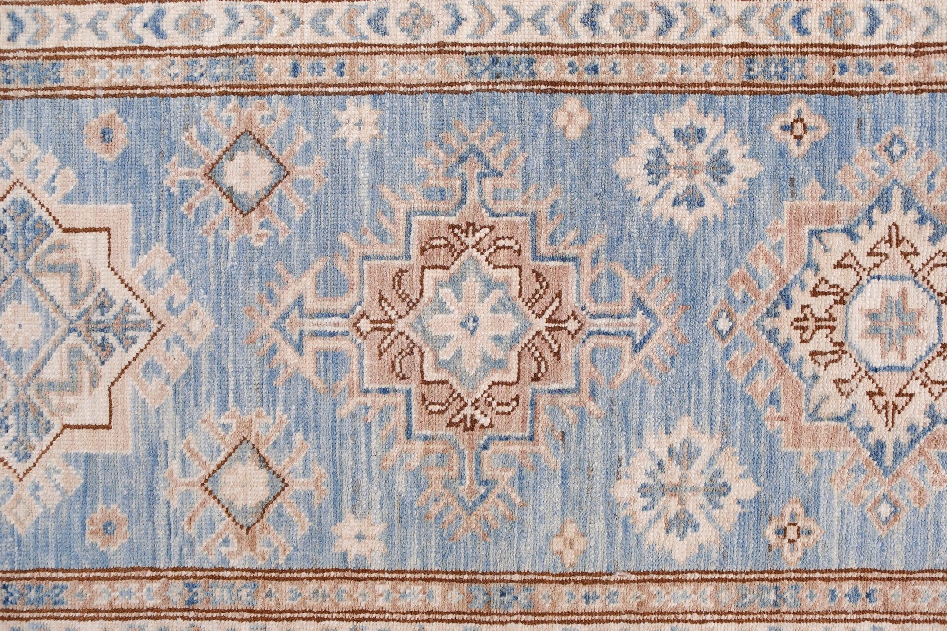 An Afghan Super Kazakh runner rug featuring traditional geometric motifs in blue and beige tones.