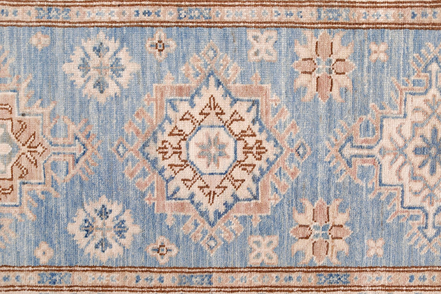 An Afghan Super Kazakh runner featuring traditional geometric motifs in blue, beige, and brown.