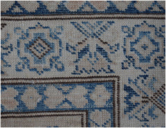 A close-up of an Afghan Super Kazakh runner featuring traditional blue and beige geometric motifs.