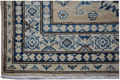 A handmade Afghan Super Kazakh runner featuring traditional blue and cream geometric patterns.