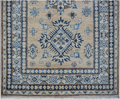 An Afghan Super Kazakh runner rug featuring a blue geometric medallion on a beige wool field.