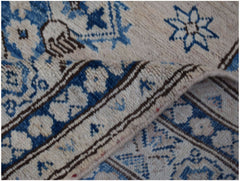 A handmade Afghan Super Kazakh runner featuring traditional blue floral motifs on a cream background.