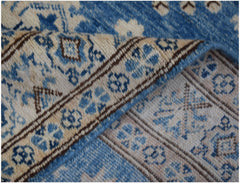 A handmade Afghan Super Kazakh runner featuring a blue and beige floral geometric pattern.