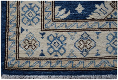 A handmade Afghan Super Kazakh runner featuring a geometric pattern in blue, beige, and brown.