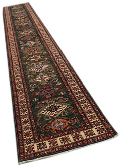 A long, handmade Afghan Super Kazakh runner rug featuring traditional geometric motifs in green.