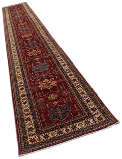 A long, handmade Afghan Super Kazakh runner rug featuring traditional geometric motifs in red.