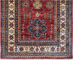 Handmade Afghan Super Kazakh runner rug featuring a red field with traditional blue floral motifs.