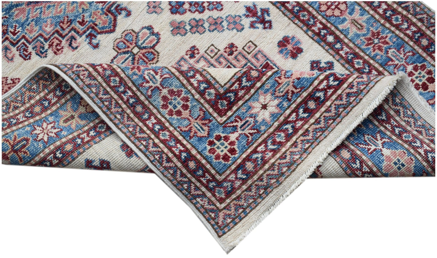 An Afghan Super Kazakh runner with traditional geometric motifs in blue, red, and cream wool.