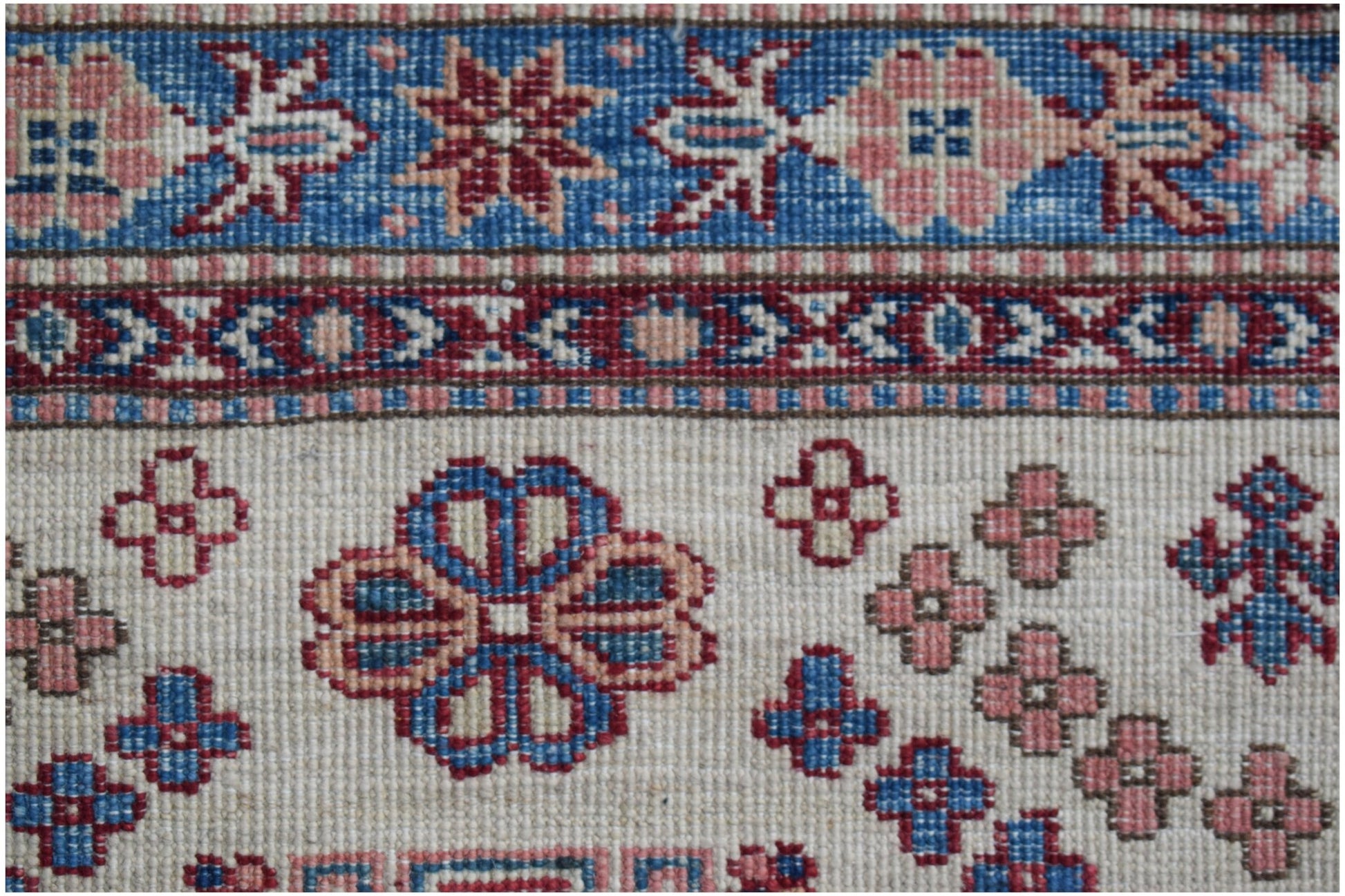 Handmade Afghan Super Kazakh runner featuring traditional floral motifs in blue and pink wool.