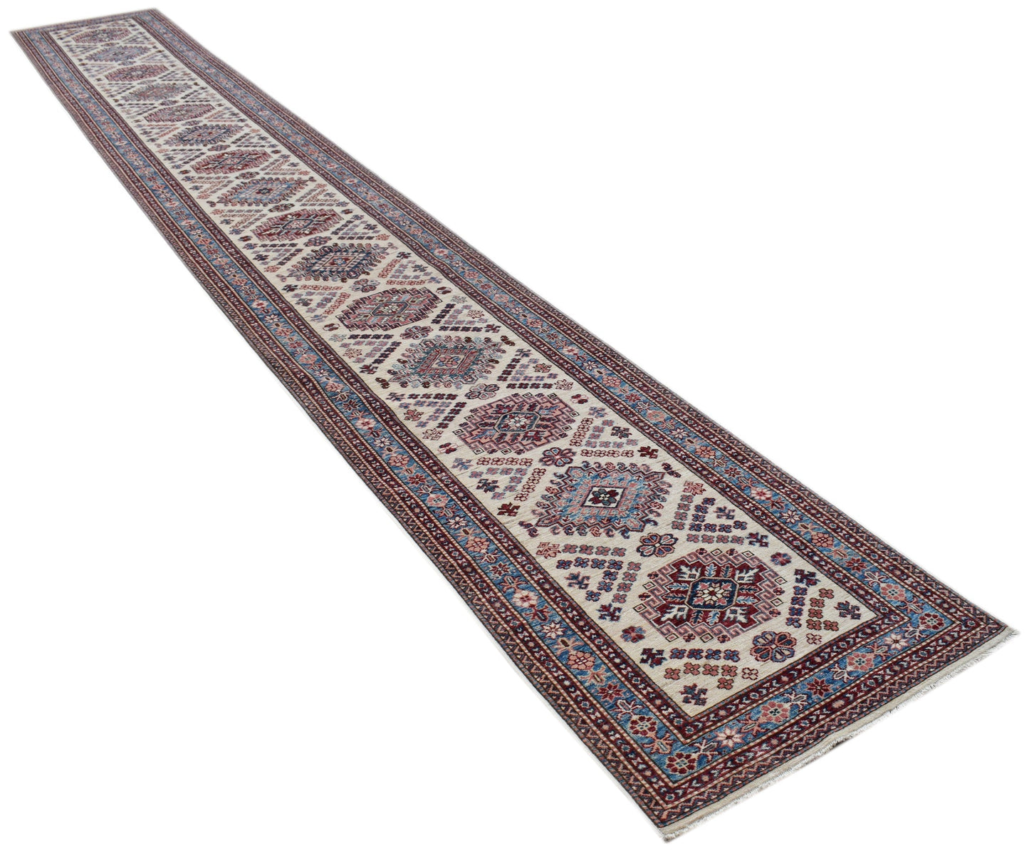 A long, handmade Afghan Super Kazakh runner rug featuring traditional geometric motifs in red and blue.