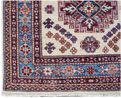 A handmade Afghan Super Kazakh runner featuring traditional geometric motifs in red and blue.