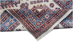 A handmade Afghan Super Kazakh runner featuring traditional geometric motifs in red and blue.