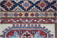 A close-up of an Afghan Super Kazakh runner featuring intricate geometric patterns in wool.