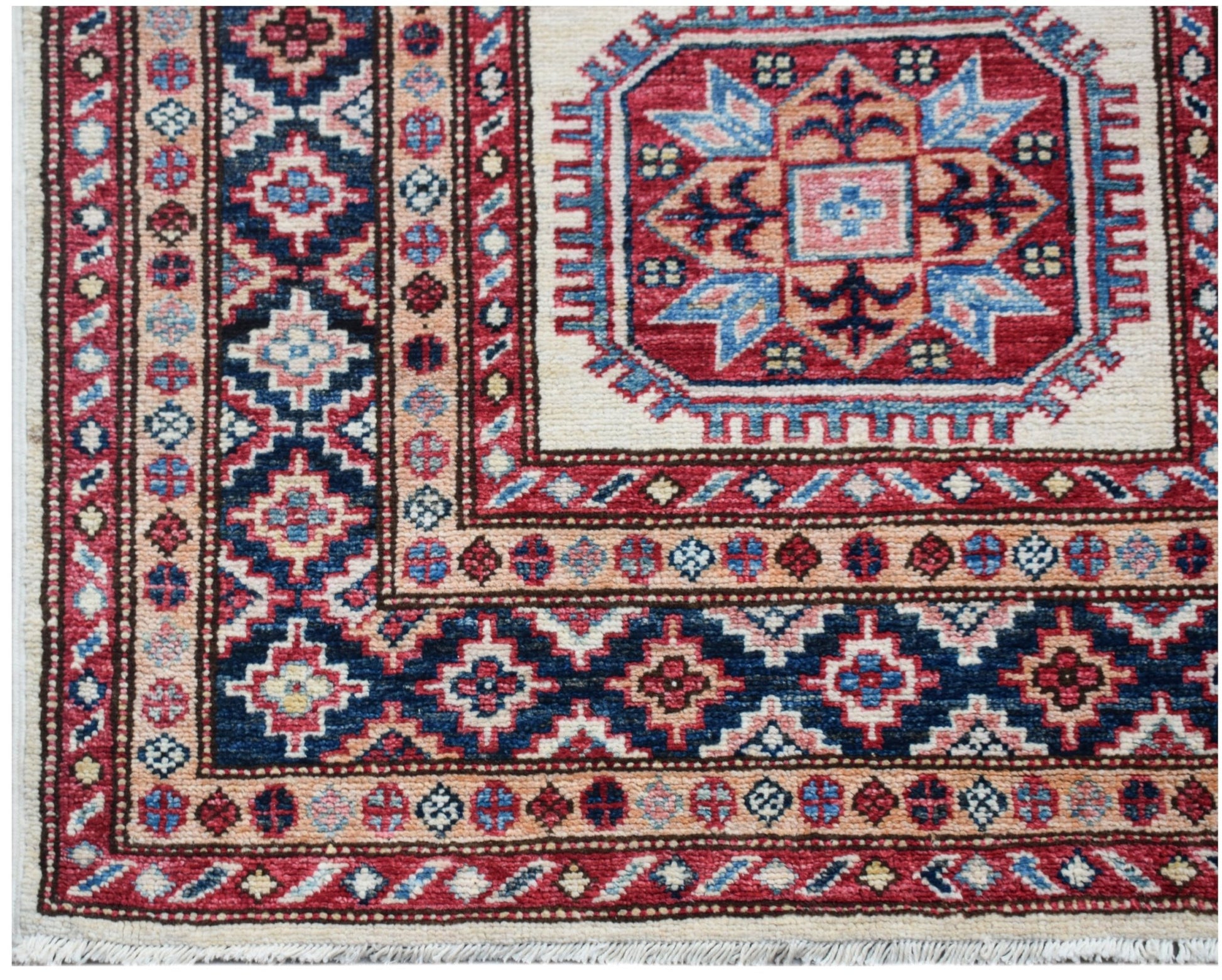 A handmade Afghan Super Kazakh runner featuring traditional geometric motifs in red and blue wool.