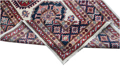 A handmade Afghan Super Kazakh runner featuring traditional geometric motifs in red and blue.