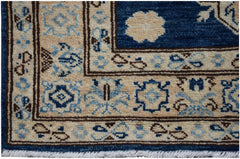A handmade Afghan Super Kazakh runner rug featuring a beige border with blue and brown patterns.