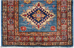 An Afghan Super Kazakh runner rug featuring a central geometric medallion on a blue field.