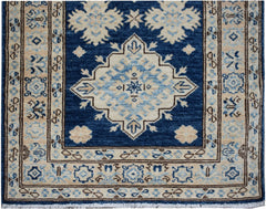 Handmade Afghan Super Kazakh runner rug featuring a central medallion in blue and beige wool.