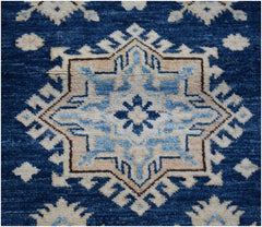 A handmade Afghan runner rug featuring a central geometric star motif in shades of blue and beige.