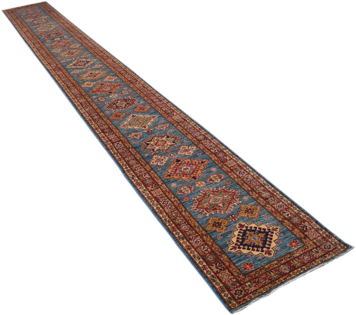 A long, handmade Afghan Super Kazakh runner rug featuring geometric patterns on a blue field.