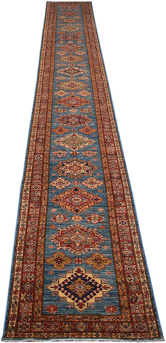 A long, handmade Afghan Super Kazakh runner rug featuring geometric patterns in blue and red.