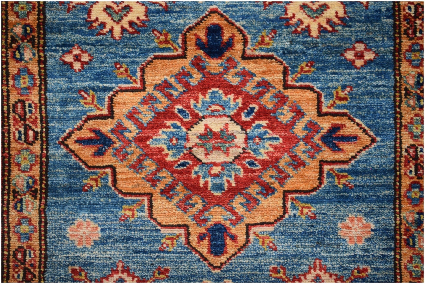Handmade Afghan Super Kazakh runner rug featuring a central geometric medallion on a blue field.