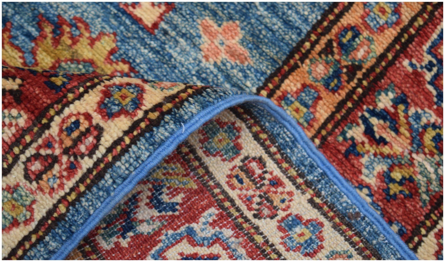 A close-up of a handmade Afghan Super Kazakh runner featuring intricate geometric floral patterns.
