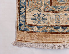 A handmade Afghan Super Kazakh runner featuring traditional blue and beige geometric motifs.