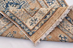 A handmade Afghan Super Kazakh runner featuring traditional blue motifs on a tan wool background.