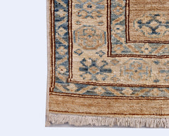A handmade Afghan Super Kazakh runner featuring traditional blue and tan geometric motifs.