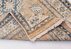 A handmade Afghan Super Kazakh runner rug featuring traditional blue motifs on a tan wool base.